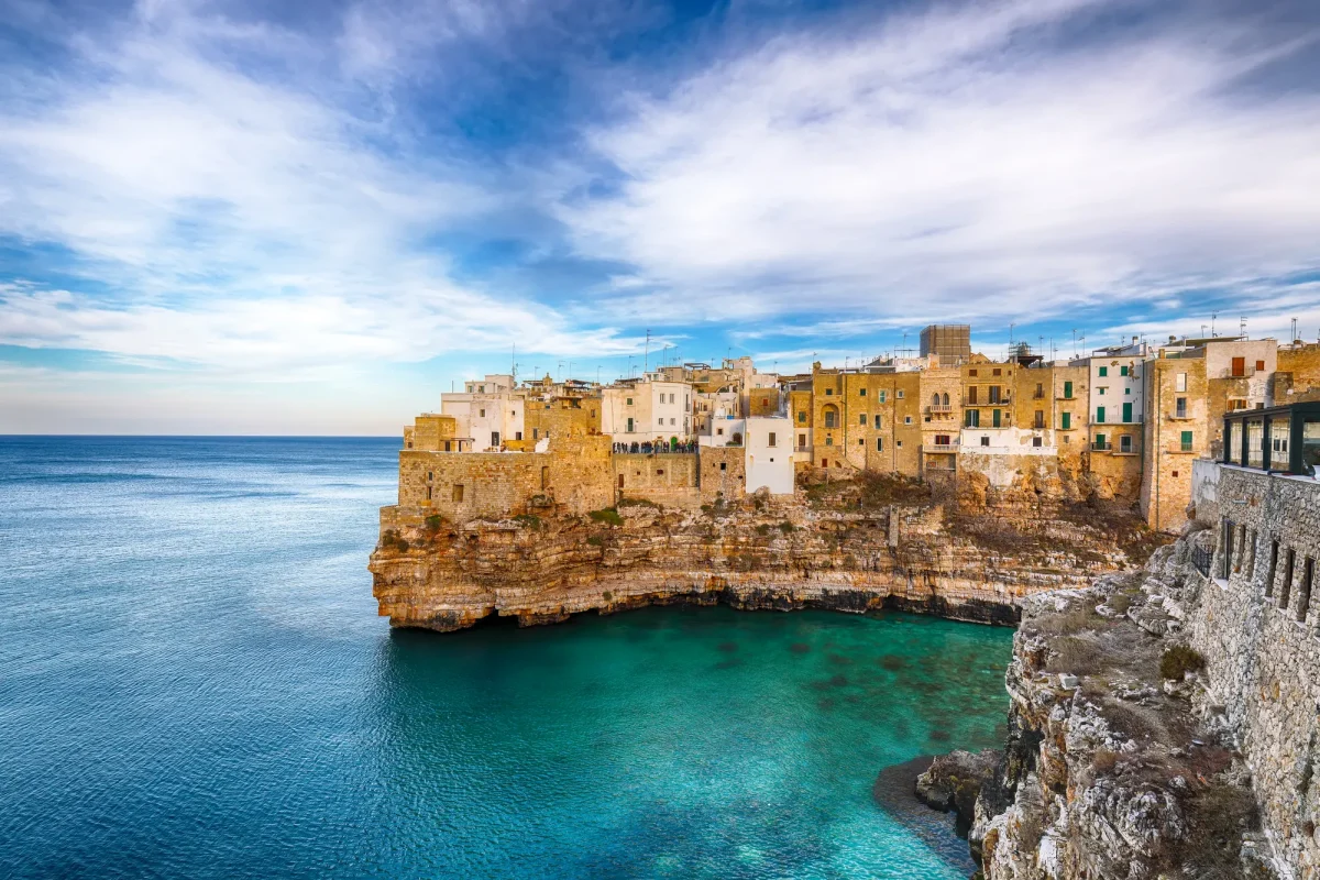 Polignano a Mare vista dal mare, con le case bianche sulla scogliera e l'acqua turchese