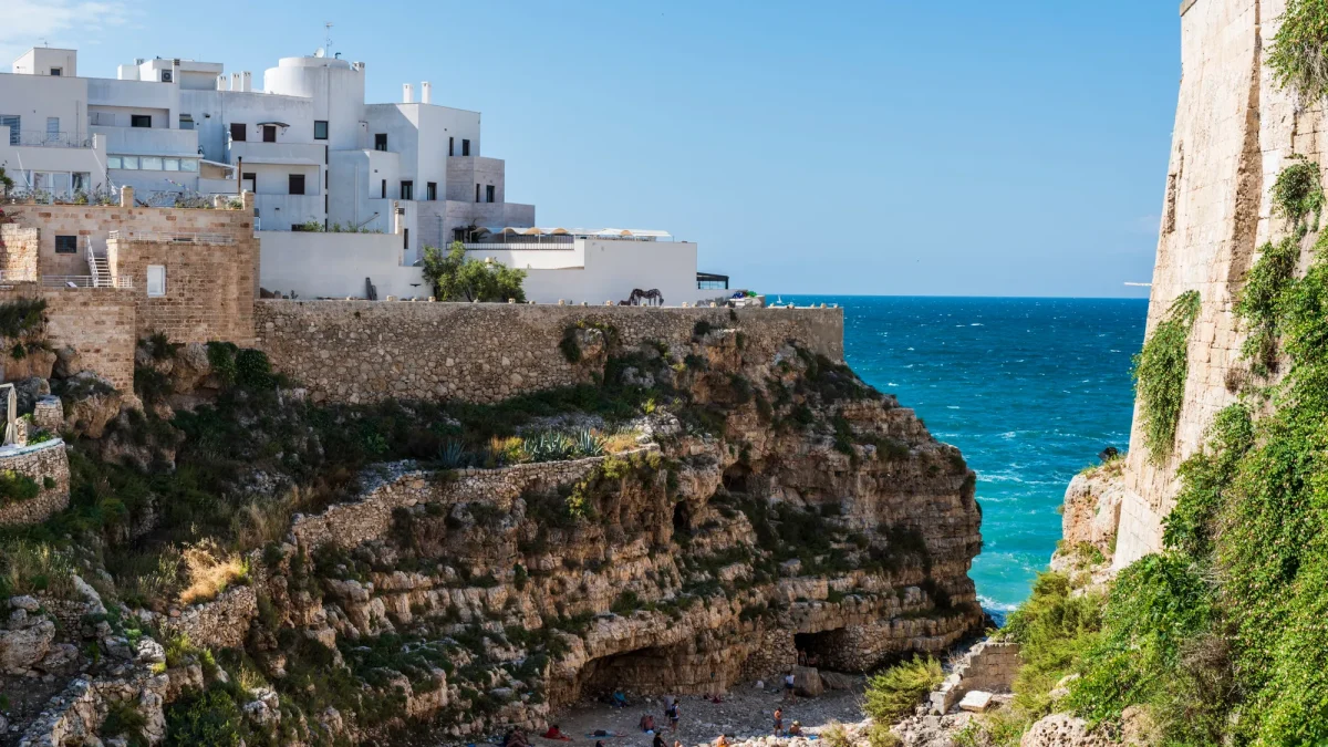 La falesia di Polignano a Mare con le case bianche affacciate sull'acqua turchese