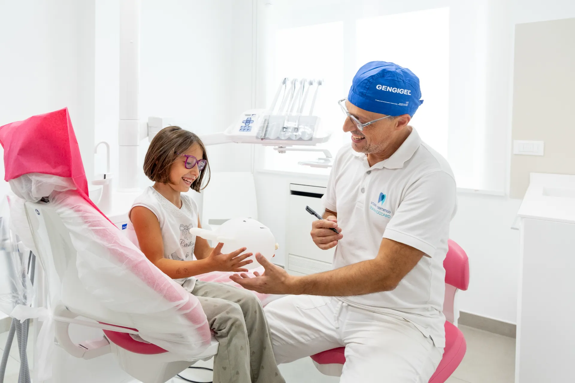 Il dentista gioca con una bambina e un guanto gonfiato prima della visita