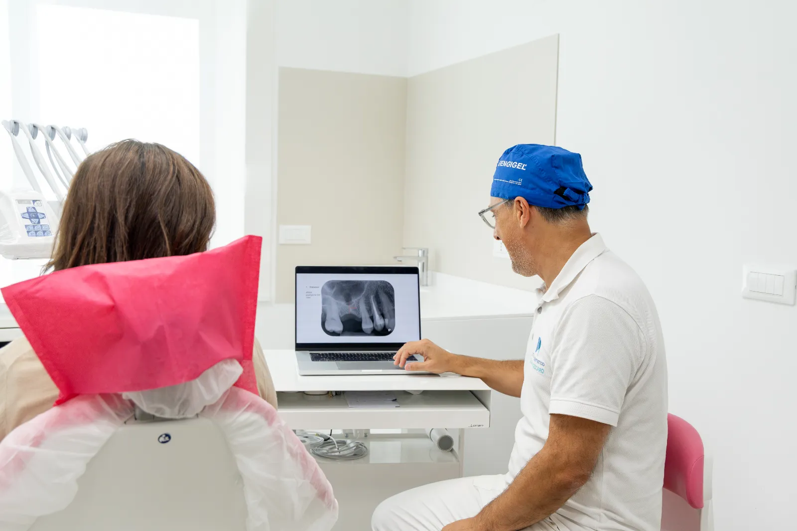 Il dentista esamina una radiografia con la paziente sulla poltrona