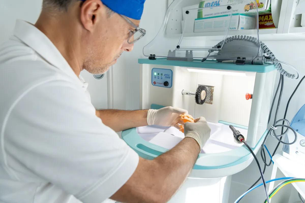 Il dentista rifinisce una protesi nel laboratorio dello studio